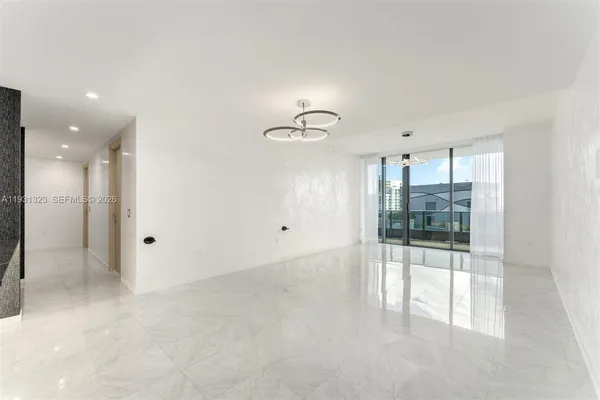 a view of a big room with windows and chandelier fan
