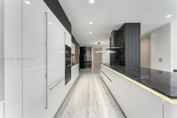 a view of a kitchen with a sink and refrigerator