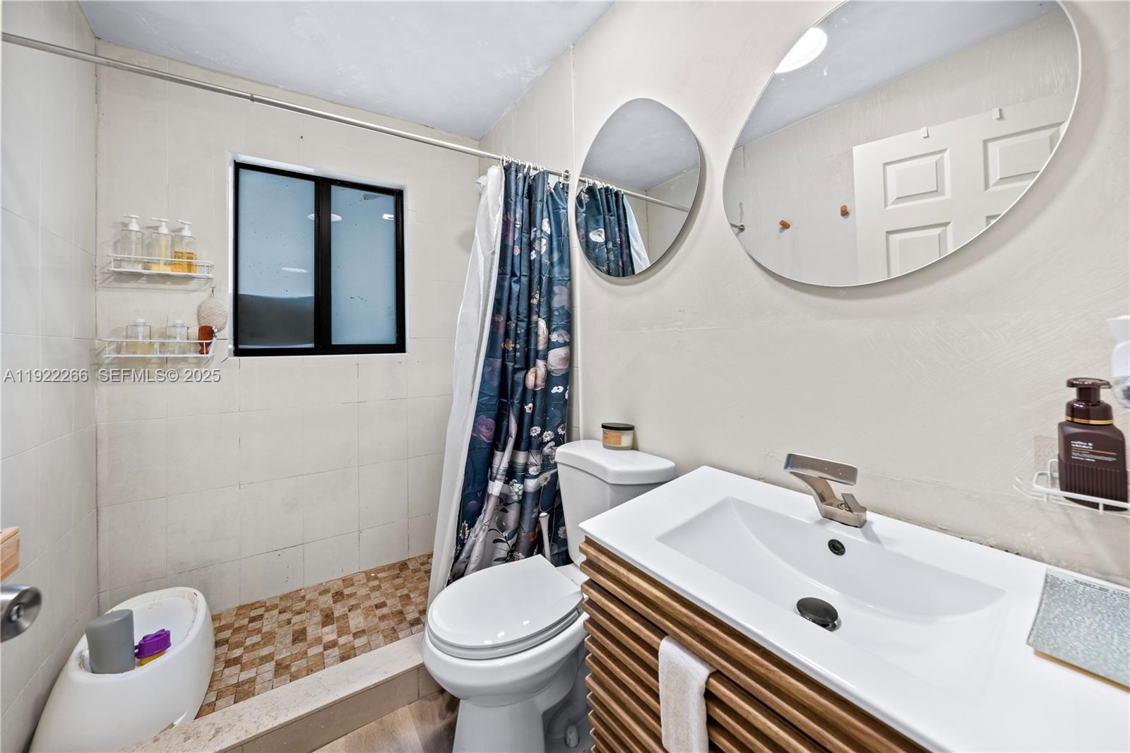 1910 Northwest 47th Street Miami, FL 33142 - Photo 20 of 32 a bathroom with a sink a toilet and a mirror