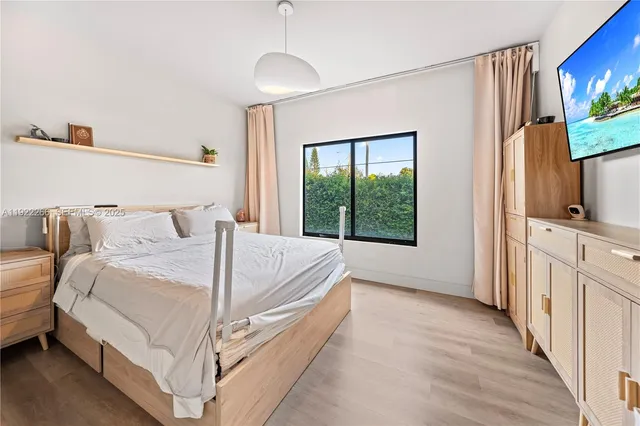 a bed room with a bed tv and a window