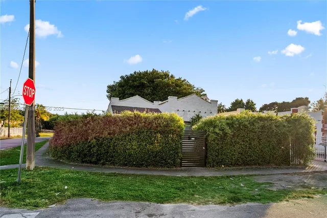 a front view of a house with a yard and tree in front of it