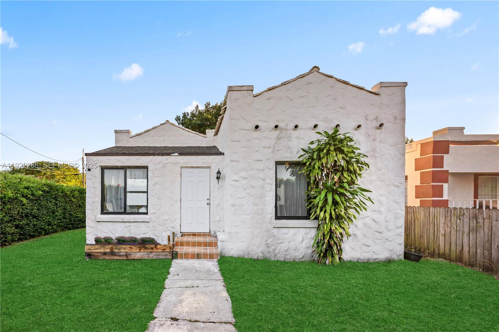1910 Northwest 47th Street Miami, FL 33142 - Photo 9 of 32 a front view of a house with a garden and plants
