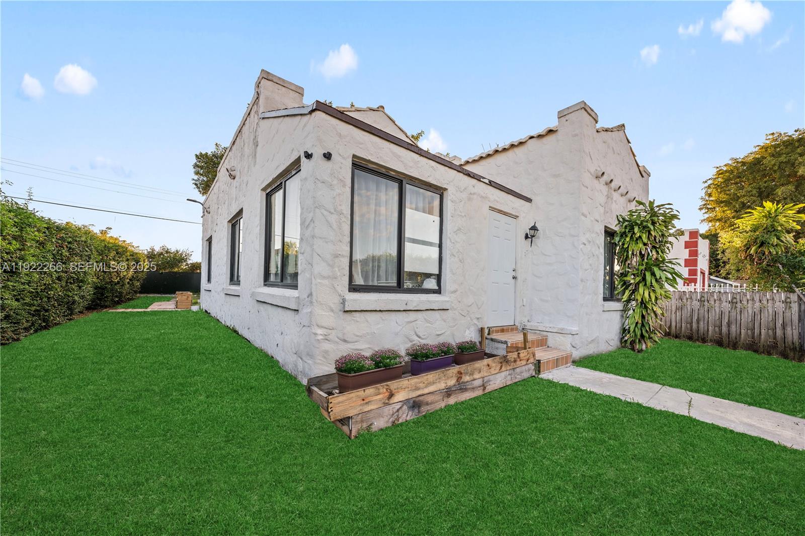 1910 Northwest 47th Street Miami, FL 33142 - Photo 10 of 32 a front view of a house with a garden and yard
