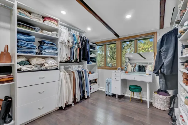 a view of walk in closet with clothes and shoes