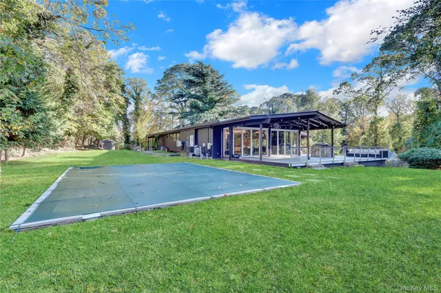 a view of an house with backyard and a tree