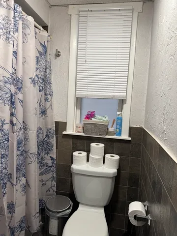 a bathroom with a toilet and a shower curtain