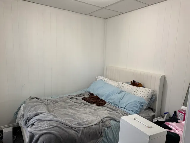 a bed sitting in a bedroom next to a window