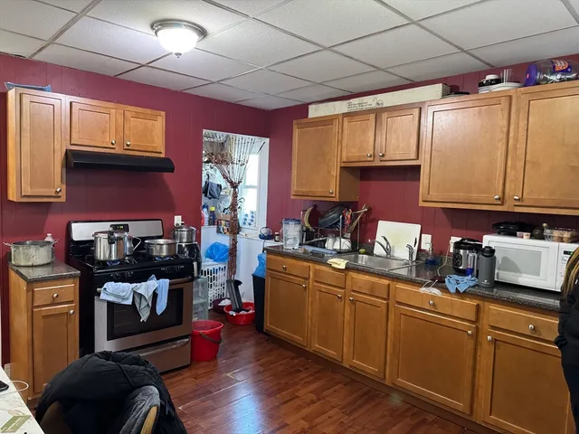 a kitchen with stainless steel appliances granite countertop a sink stove and wooden cabinets