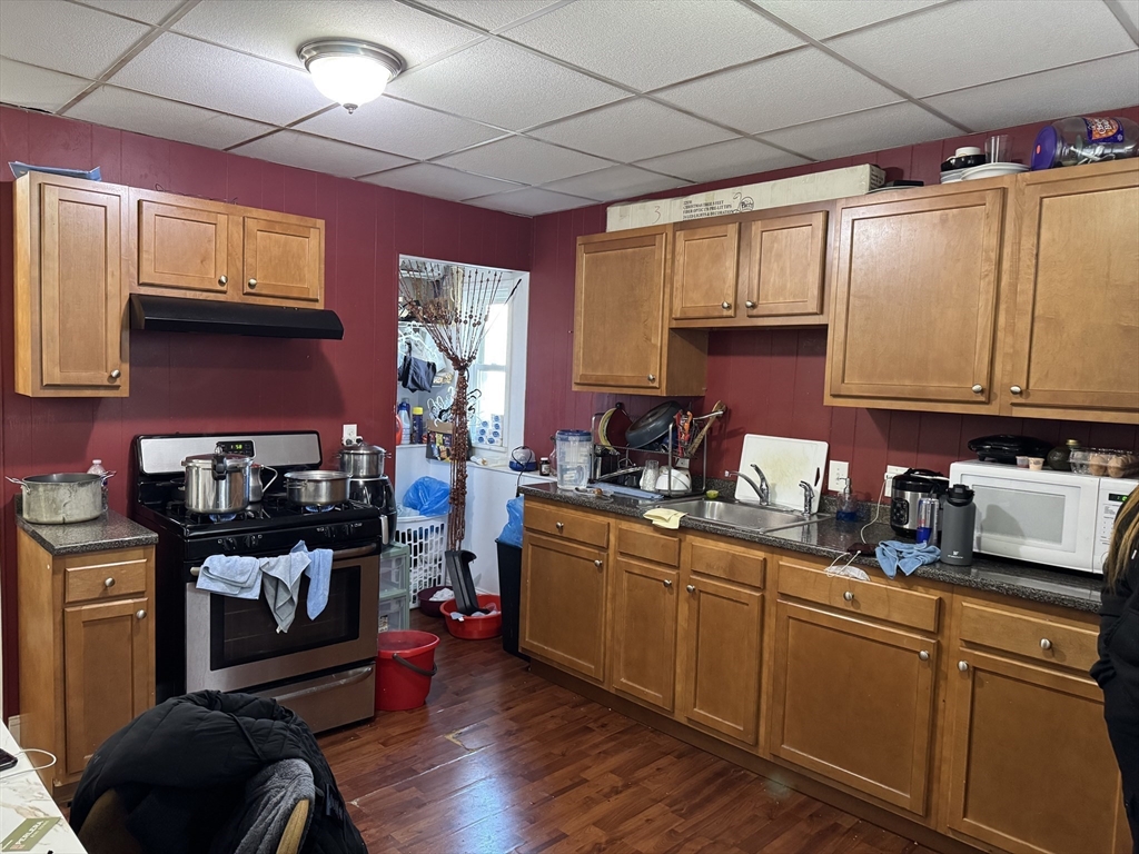289 Chelsea Street Boston, MA 02128 - Photo 9 of 23 a kitchen with stainless steel appliances granite countertop a sink stove and wooden cabinets