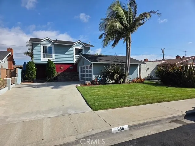 a front view of a house with a garden and trees