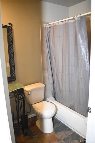 a white toilet sitting next to a shower curtain