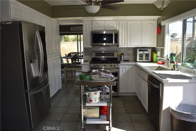 a kitchen with stainless steel appliances granite countertop a refrigerator stove top oven a sink and dishwasher