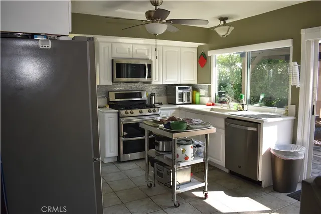 a kitchen with stainless steel appliances a stove a sink and a refrigerator