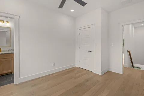 a view of a livingroom with wooden floor and a ceiling fan