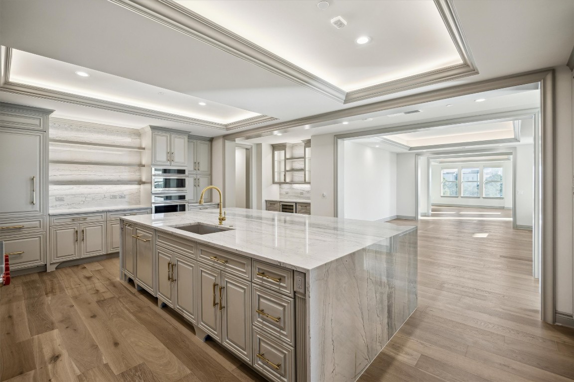 1717 Bissonnet Street, Unit 1802 Houston, TX 77005 - Photo 4 of 46 Beautiful wide plank hardwood floors throughout, Quartzite waterfall island and counters, built-in panel front refrigerator and dishwasher.