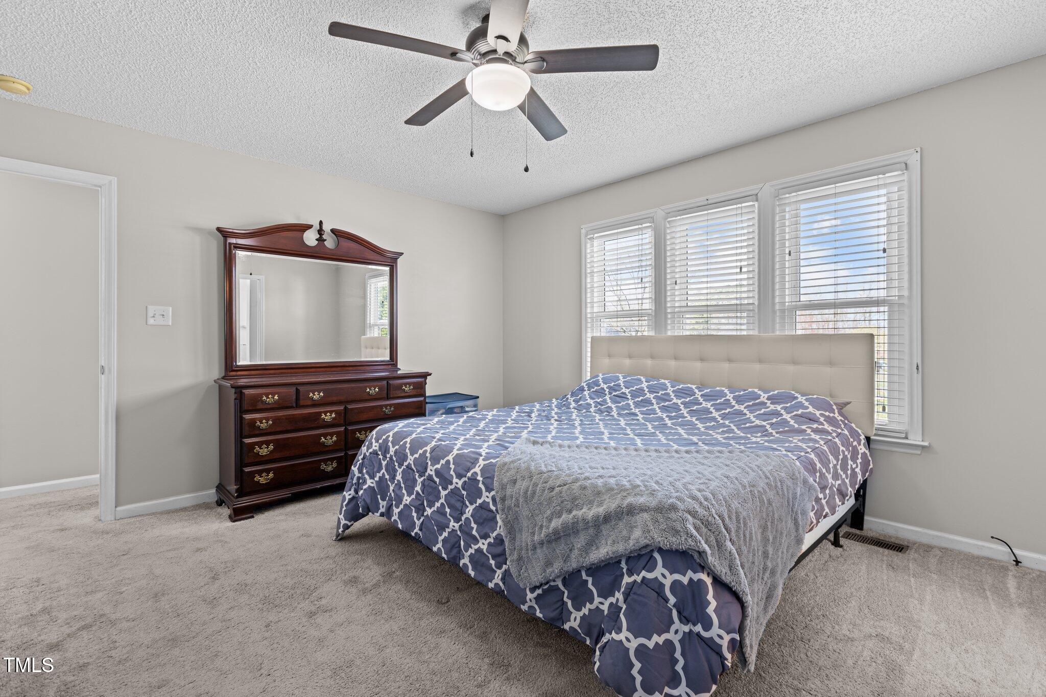 1408 Harvey Johnson Road Raleigh, NC 27603 - Photo 18 of 48 a bedroom with a bed and a flat screen tv