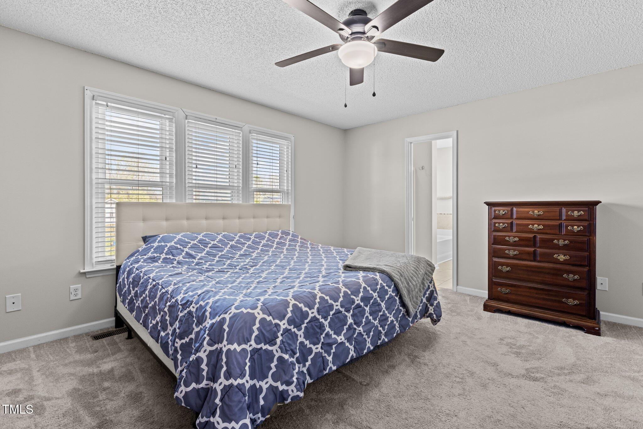 1408 Harvey Johnson Road Raleigh, NC 27603 - Photo 19 of 48 a bedroom with a bed and a chandelier