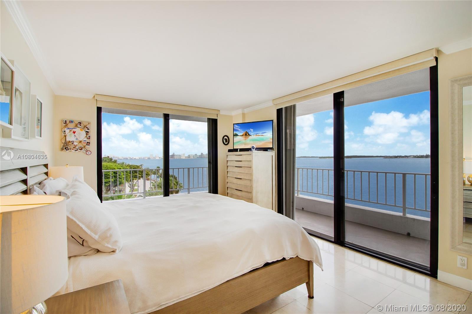 200 Southeast 15th Road, Unit 6D Miami, FL 33129 - Photo 5 of 20 a bedroom with a large bed and a flat tv screen on dresser