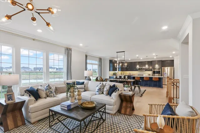 a living room with furniture kitchen view and large windows