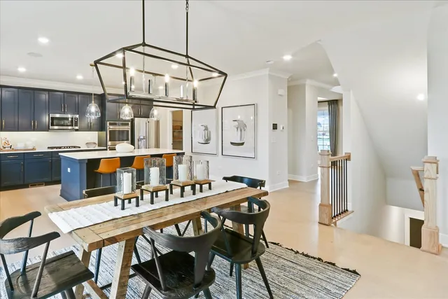 a open kitchen with stainless steel appliances granite countertop a dining table chairs and granite counter tops