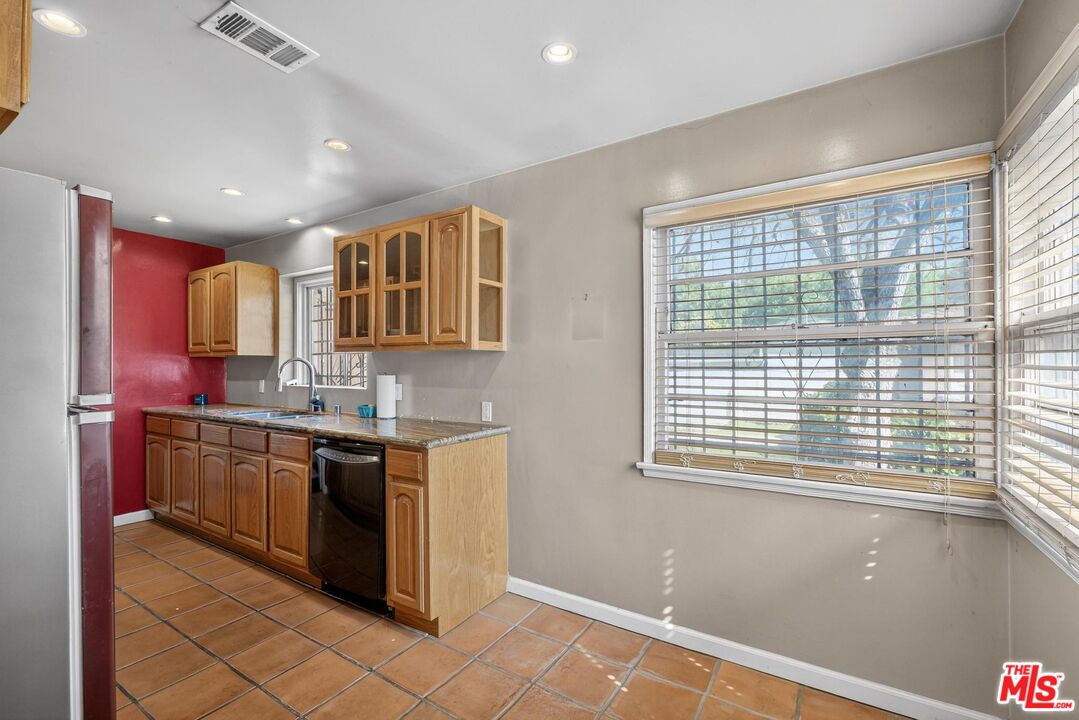 3692 Buckingham Road Los Angeles, CA 90016 - Photo 17 of 40 a kitchen with stainless steel appliances granite countertop a stove and a sink