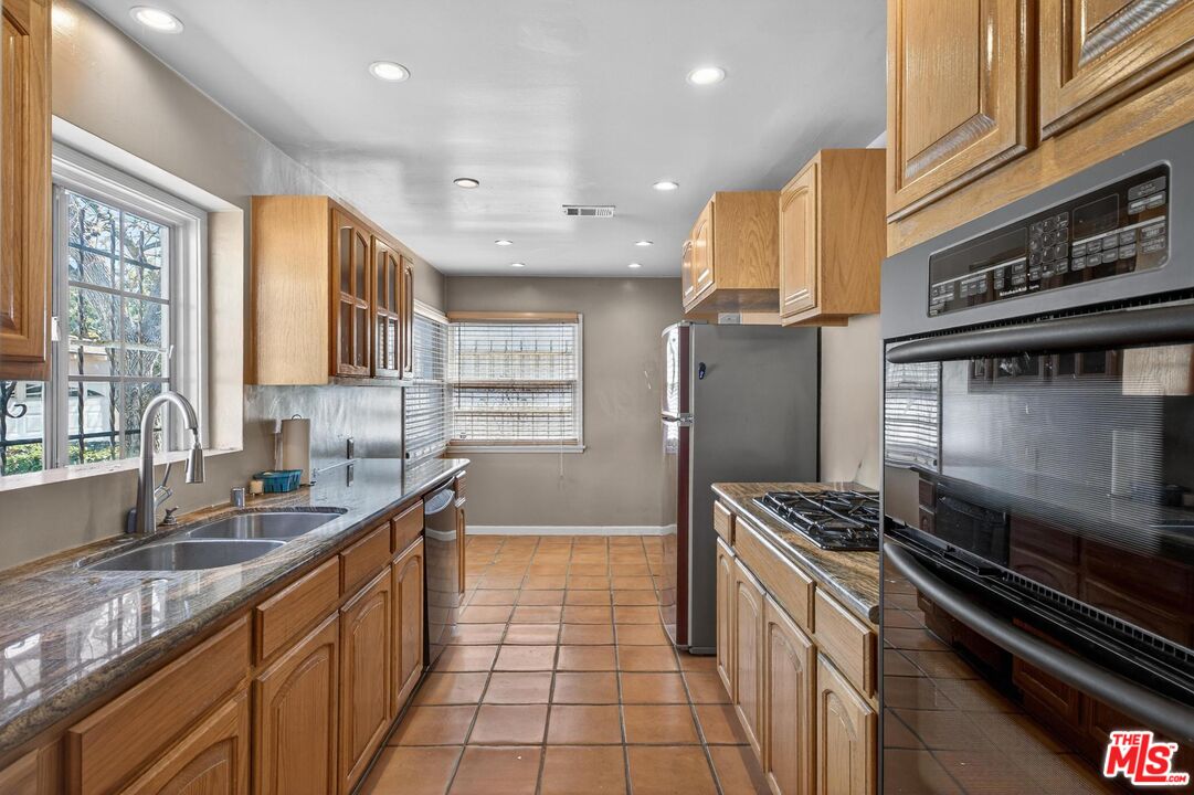 3692 Buckingham Road Los Angeles, CA 90016 - Photo 21 of 40 a kitchen with stainless steel appliances granite countertop a sink and a stove