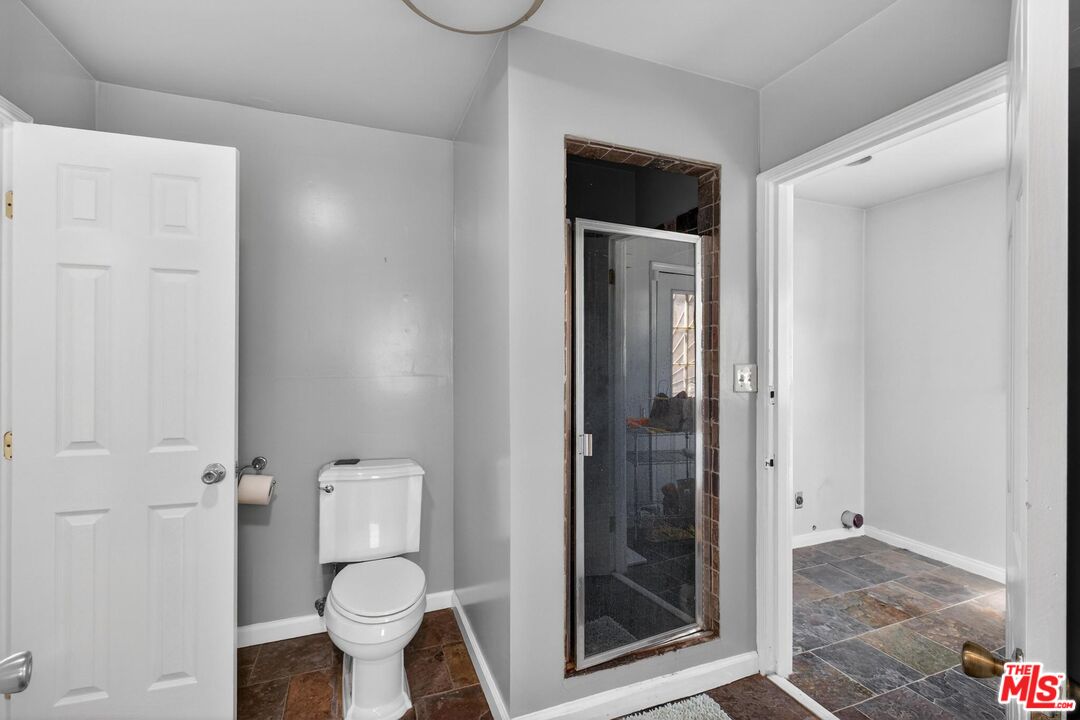 3692 Buckingham Road Los Angeles, CA 90016 - Photo 25 of 40 a bathroom with a toilet and a shower