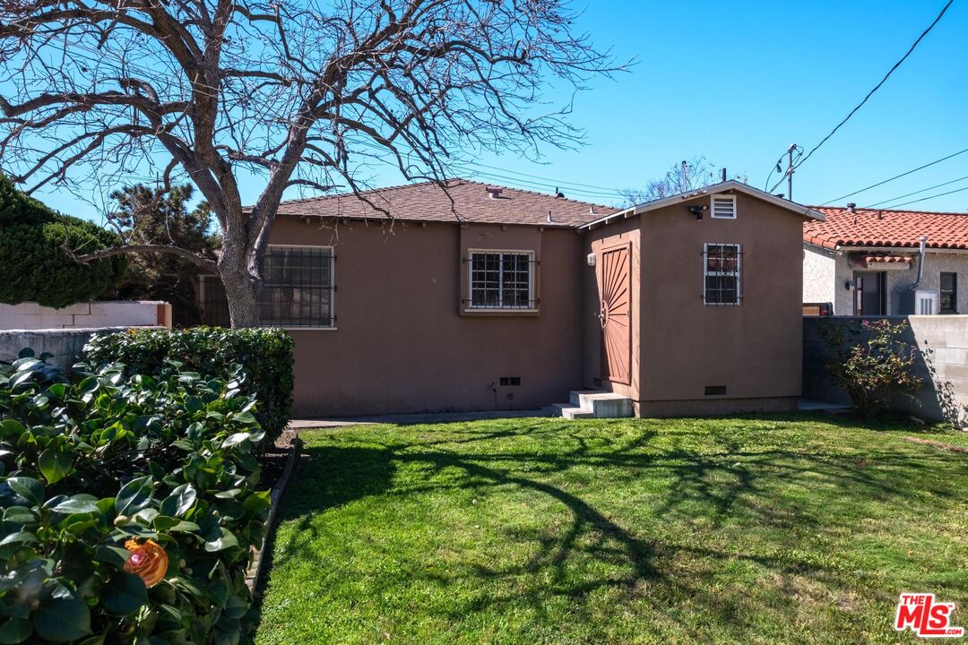 3692 Buckingham Road Los Angeles, CA 90016 - Photo 39 of 40 a front view of a house with a yard and garage