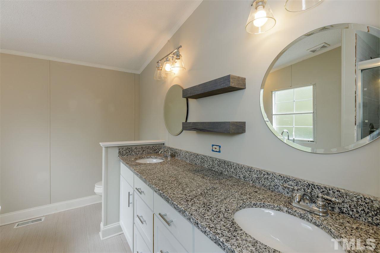2162 Eldridge Road Newton Grove, NC 28366 - Photo 10 of 22 New vanity, shelving, and custom tiled full shower separate from tub