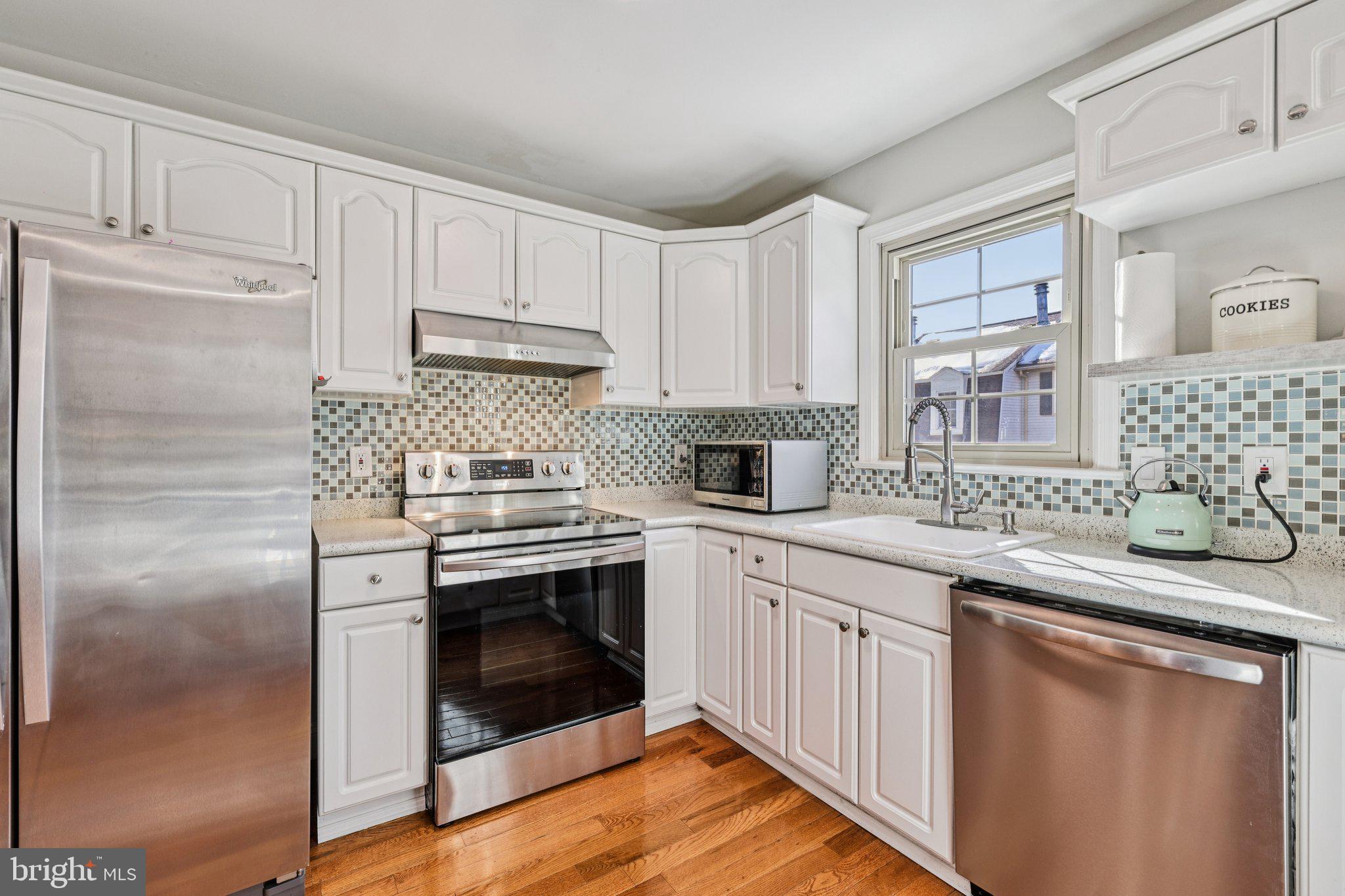 10616 Pennydog Lane Silver Spring, MD 20902 - Photo 13 of 58 a kitchen with stainless steel appliances granite countertop a stove a sink and a refrigerator