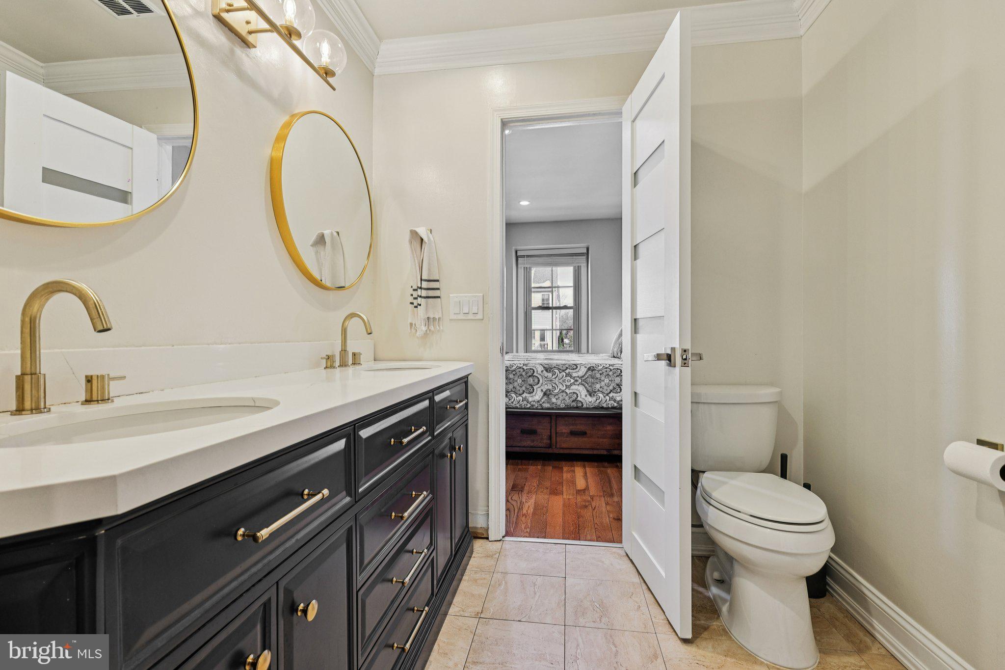 10616 Pennydog Lane Silver Spring, MD 20902 - Photo 21 of 58 a spacious bathroom with a granite countertop sink a toilet and a mirror