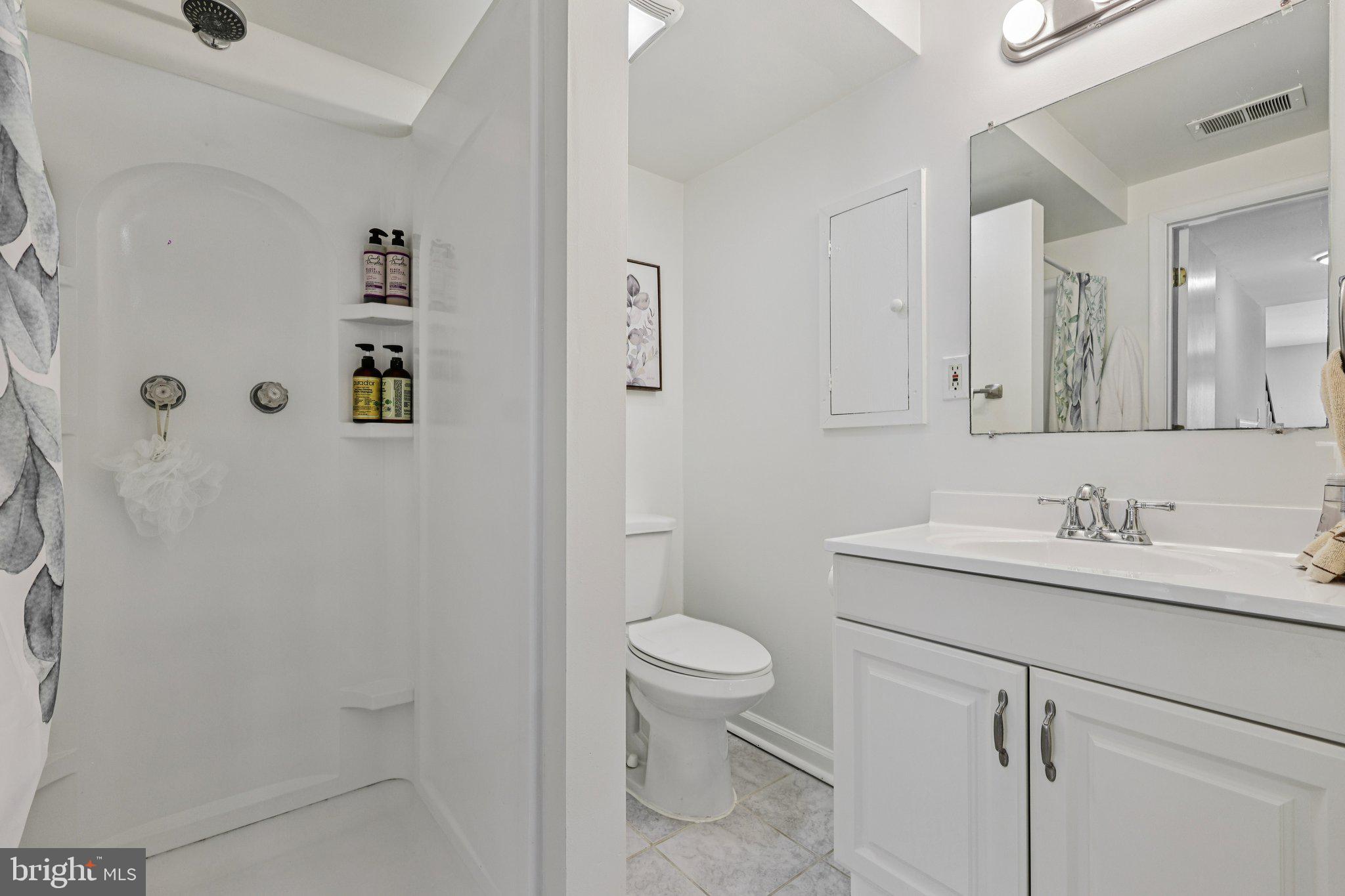 10616 Pennydog Lane Silver Spring, MD 20902 - Photo 37 of 58 a bathroom with a granite countertop sink a toilet and a mirror