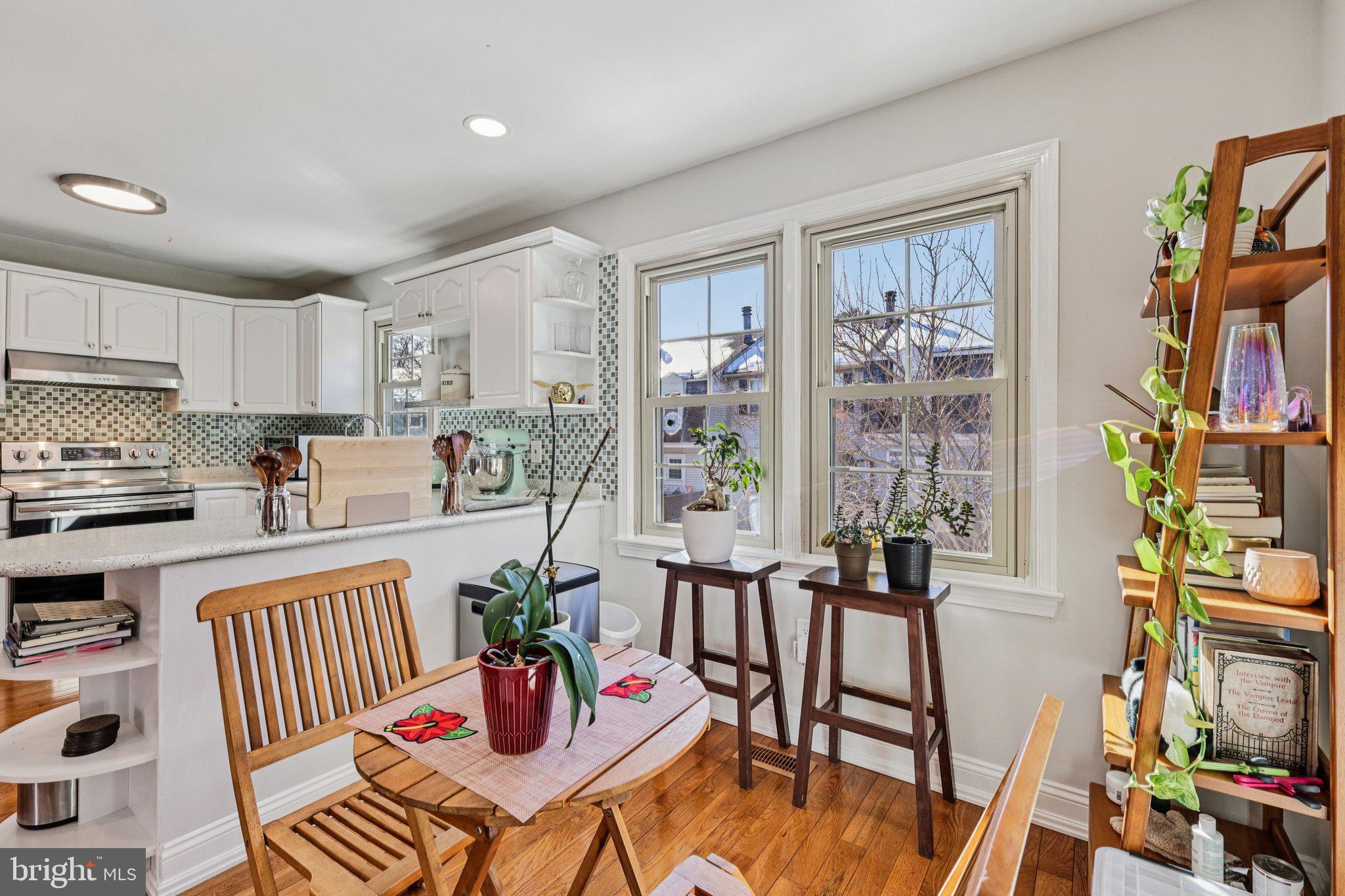 10616 Pennydog Lane Silver Spring, MD 20902 - Photo 10 of 58 a kitchen with stainless steel appliances wooden floor dining table and chairs