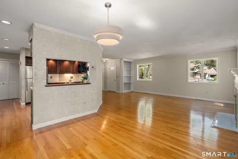 a view of a livingroom with wooden floor and a ceiling fan