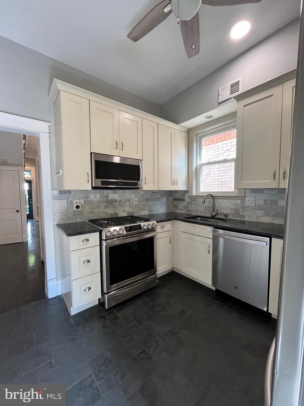 547 4th Street Southeast Washington, DC 20003 - Photo 5 of 13 a kitchen with granite countertop a stove a sink and a microwave