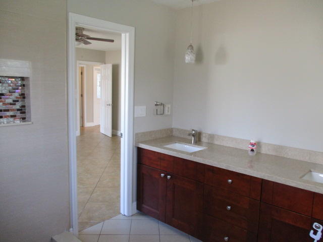 8904 Southwest 16th Street Boca Raton, FL 33433 - Photo 20 of 29 a bathroom with a granite countertop sink a mirror and a vanity