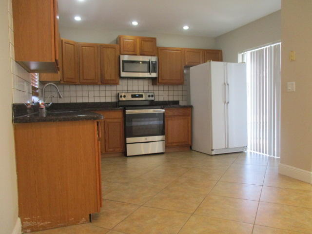 8904 Southwest 16th Street Boca Raton, FL 33433 - Photo 8 of 29 a kitchen with stainless steel appliances granite countertop a refrigerator a stove a sink and a oven