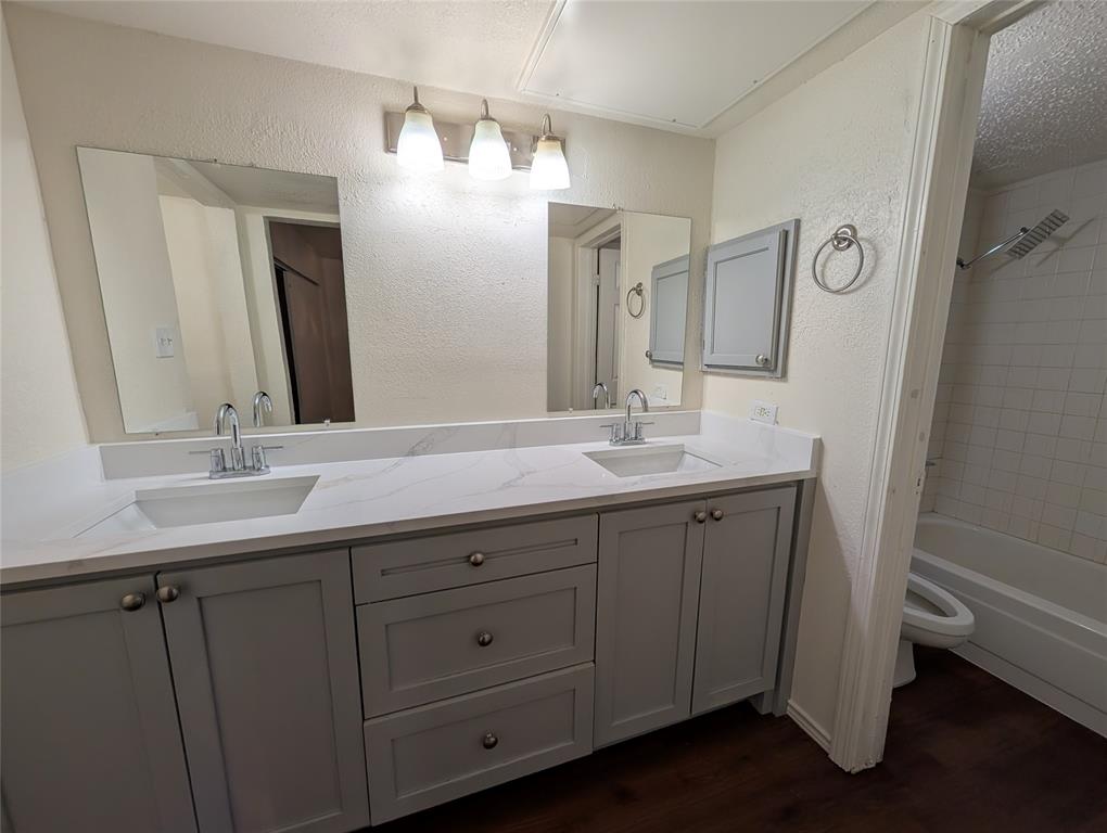 9833 Walnut Street, Unit Q201 Dallas, TX 75243 - Photo 6 of 9 a bathroom with double vanity sink and a mirror