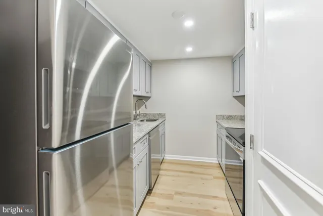 a kitchen with granite countertop a sink dishwasher stove and cabinets