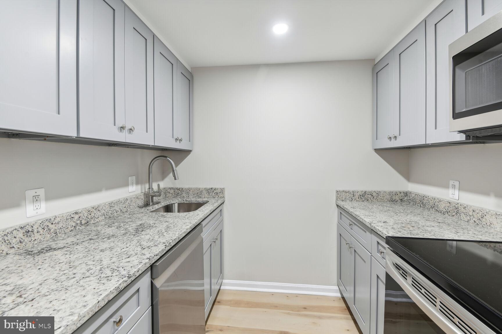 327-329 8th Street Northeast, Unit 9 Washington, DC 20002 - Photo 5 of 28 a kitchen with granite countertop a sink dishwasher stove and cabinets