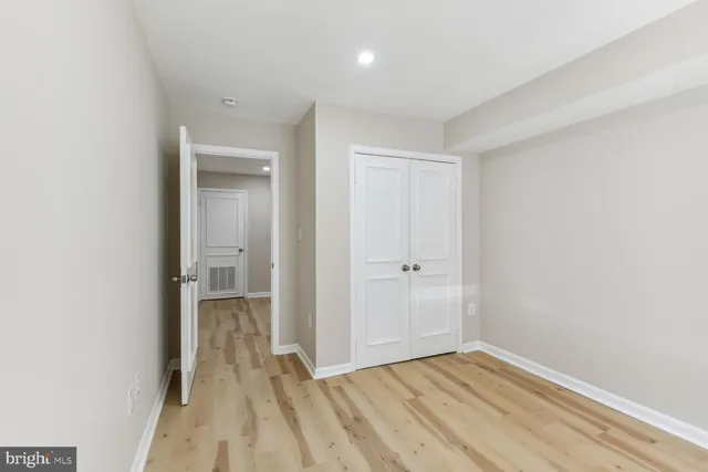 a view of a room with wooden floor and a hallway