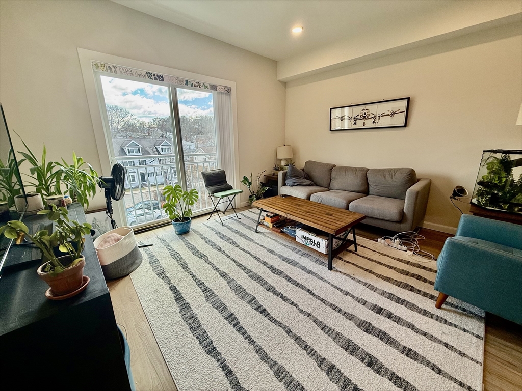 458 Washington Street, Unit 308 Boston, MA 02135 - Photo 1 of 14 a living room with furniture and a large window