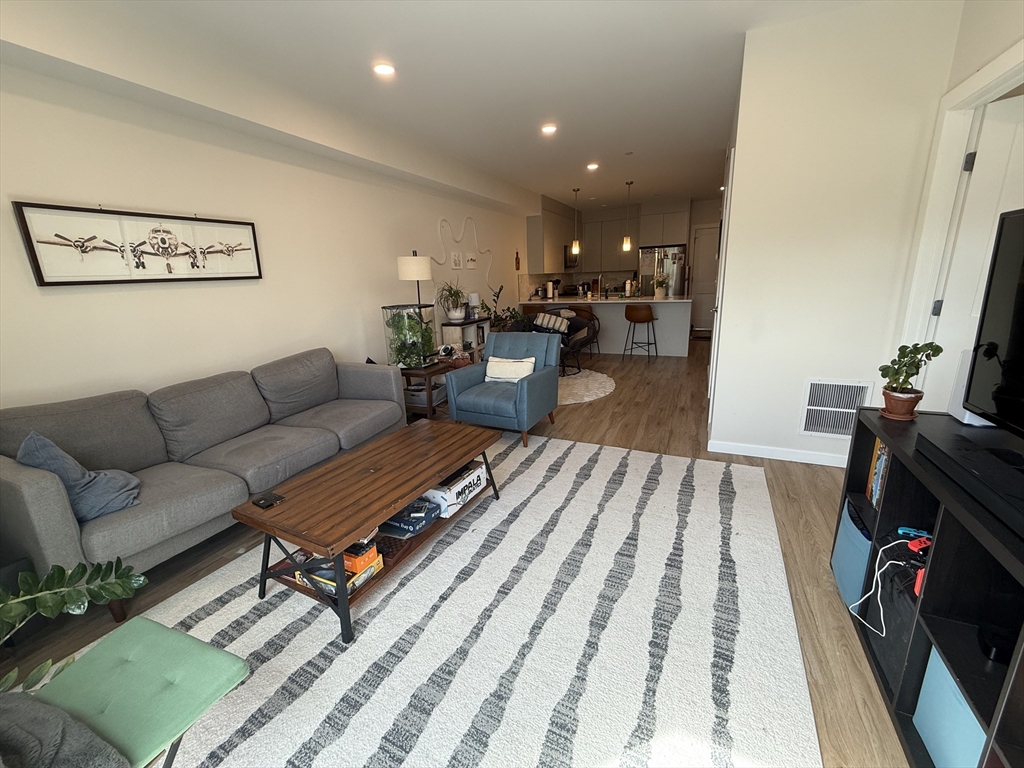 458 Washington Street, Unit 308 Boston, MA 02135 - Photo 2 of 14 a living room with furniture and a rug