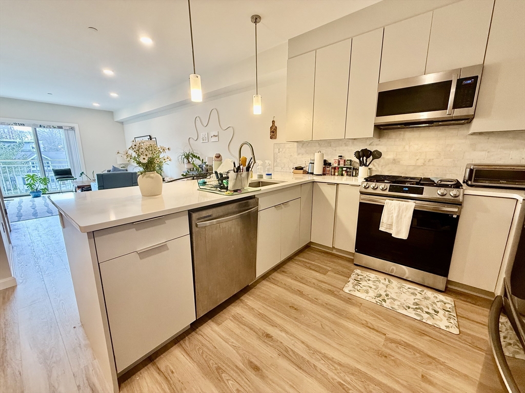 458 Washington Street, Unit 308 Boston, MA 02135 - Photo 4 of 14 a kitchen with a sink stove and microwave