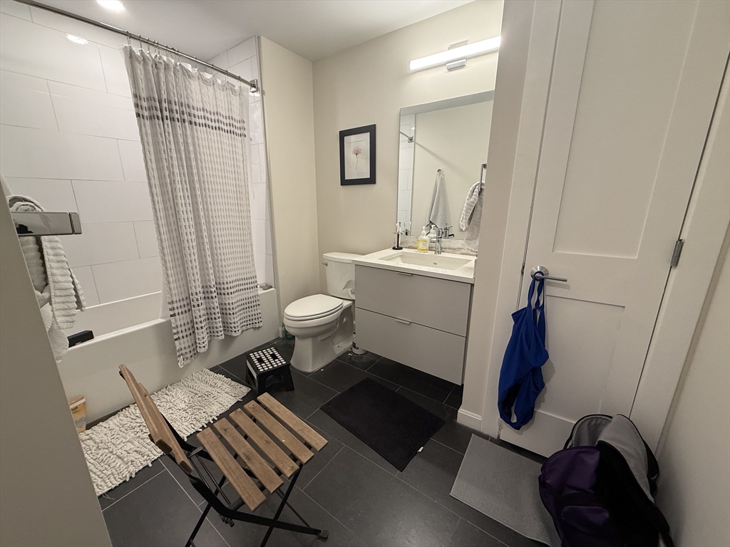 458 Washington Street, Unit 308 Boston, MA 02135 - Photo 9 of 14 a bathroom with a sink toilet and shower
