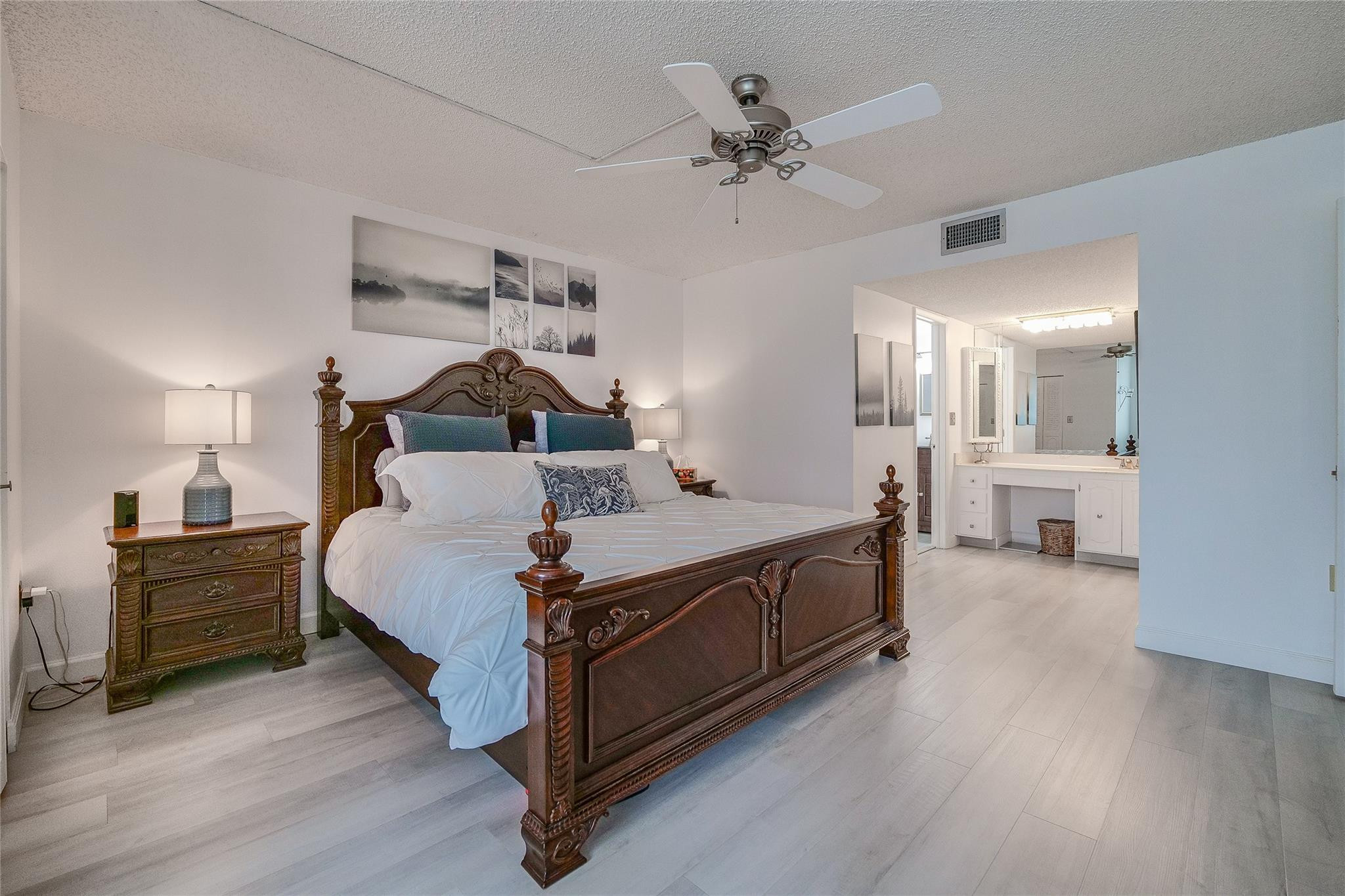 3930 Inverrary Boulevard, Unit 407D Lauderhill, FL 33319 - Photo 15 of 60 a spacious bedroom with a bed and a chandelier
