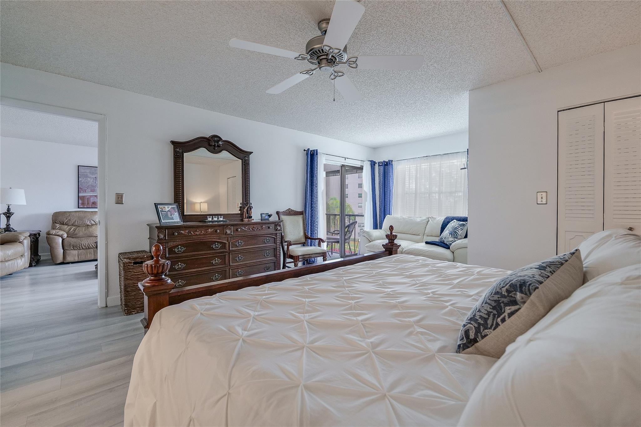 3930 Inverrary Boulevard, Unit 407D Lauderhill, FL 33319 - Photo 18 of 60 a bedroom with a bed a chandelier and dresser