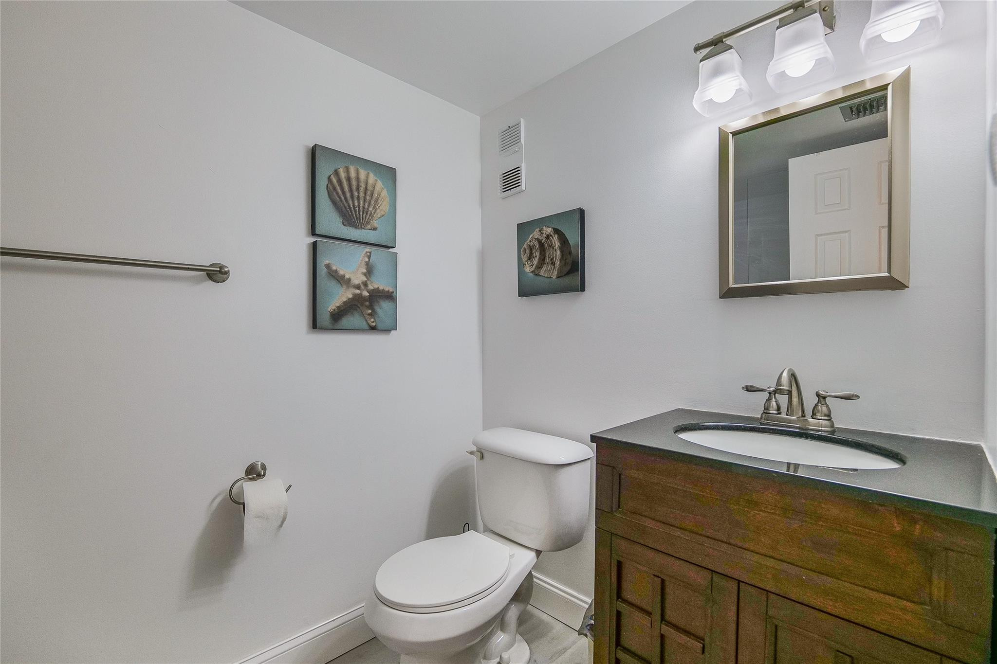 3930 Inverrary Boulevard, Unit 407D Lauderhill, FL 33319 - Photo 20 of 60 a bathroom with a toilet a sink and mirror