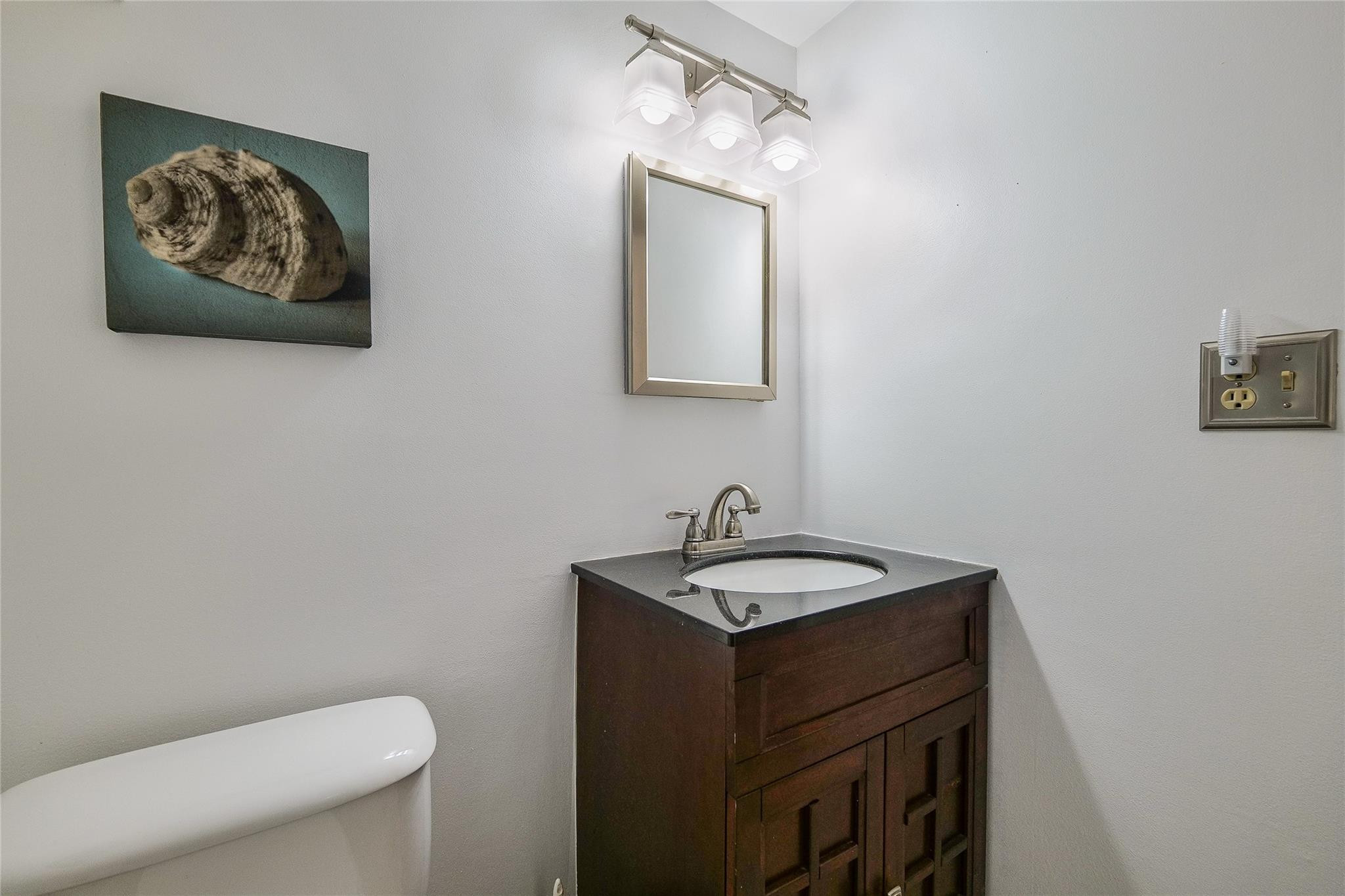 3930 Inverrary Boulevard, Unit 407D Lauderhill, FL 33319 - Photo 21 of 60 a bathroom with a toilet a sink and mirror