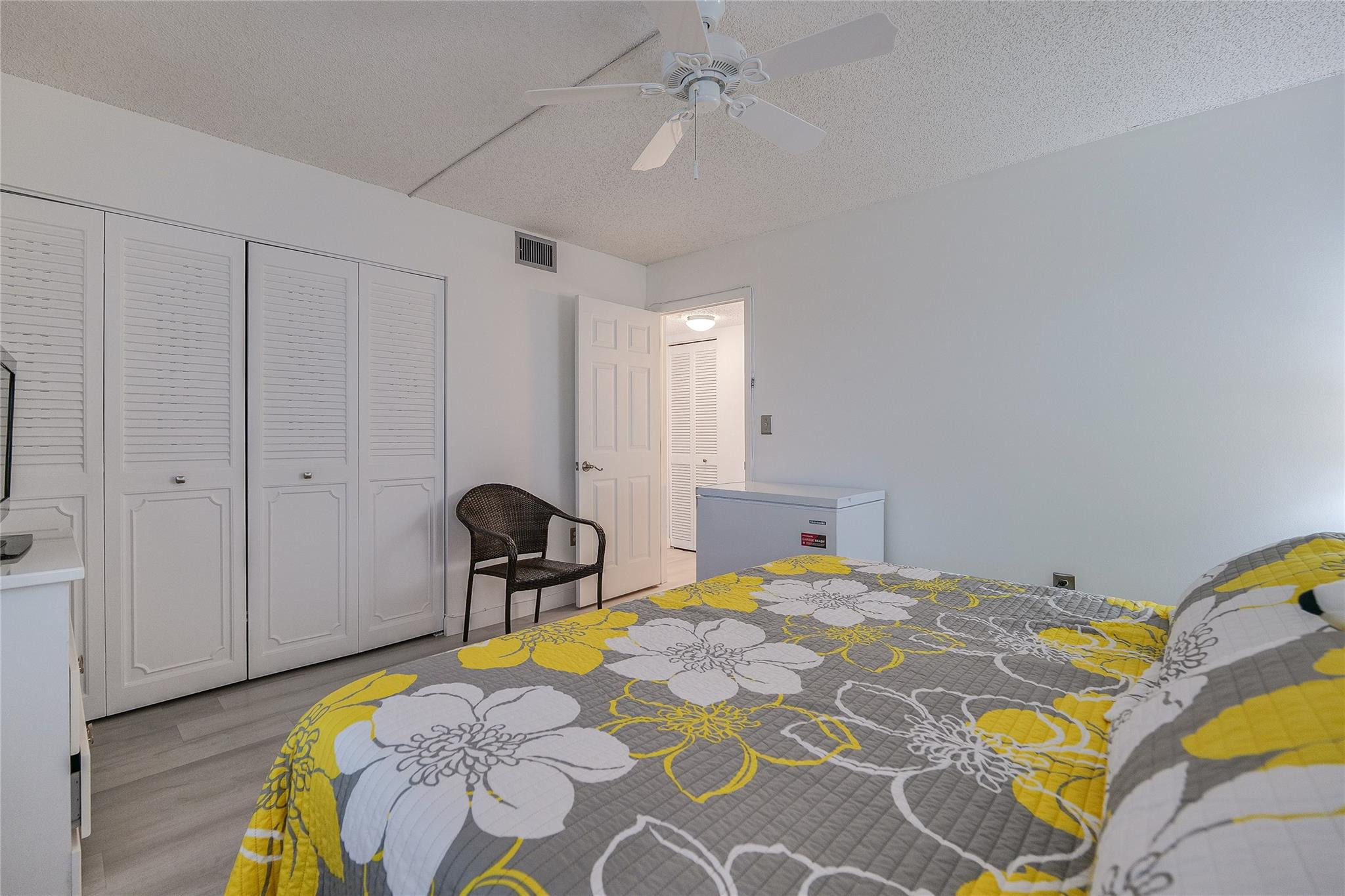 3930 Inverrary Boulevard, Unit 407D Lauderhill, FL 33319 - Photo 25 of 60 a bedroom with a bed and a chair